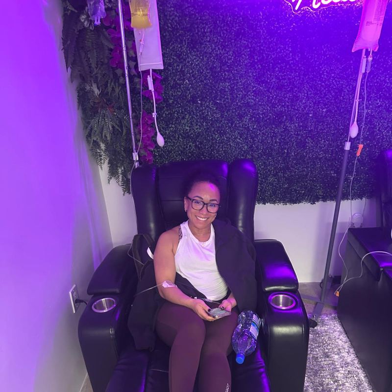 A client relaxing in a recliner during her IV drip at the studio